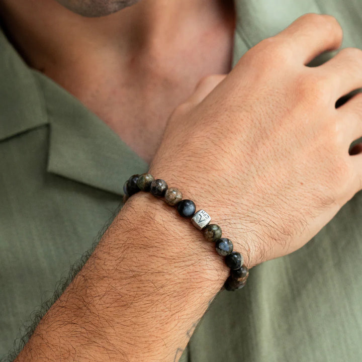 Alexander Lynggaard Armband Glaucophane 8mm visat på en mans hand, pärlor i blåbruna nyanser. Modell C01180-001.