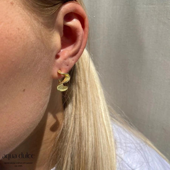 Aqua Dulce Rhumba Medium Hoop Creole i matt guldfärgad look bärs i örat, modell 5320-5320-2.