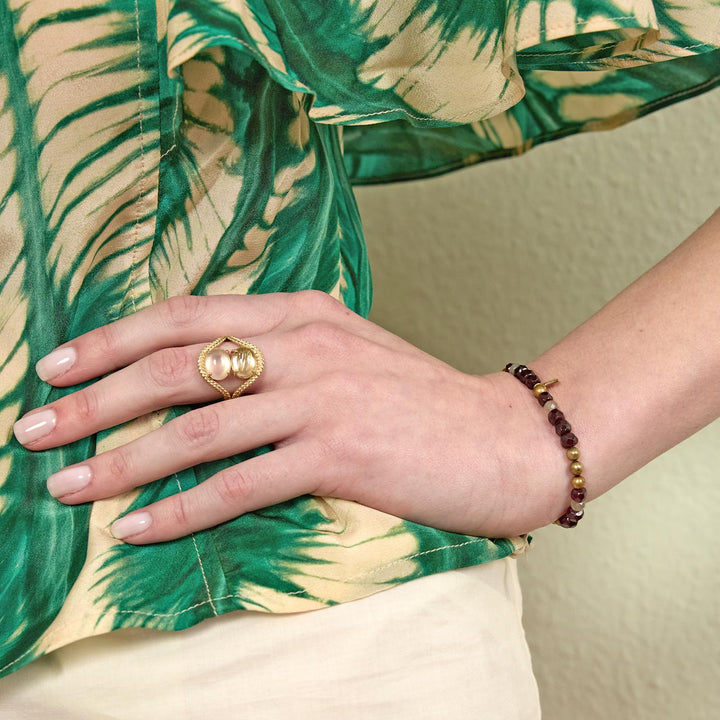 carre-simone-armband-med-granat-gyllene-pärla-och-labradorit sett till hands, granatröda och gyllene pärlor. Modell fb4658gabglb