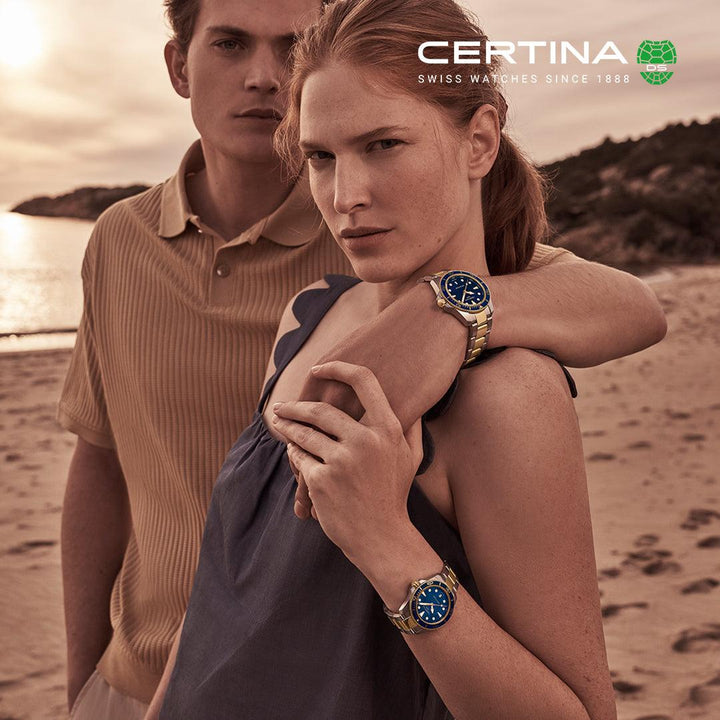 Certina DS Action blå urtavla PVD 40 mm Quartz C0484102204100 visad på kvinnans hand, strandbakgrund, modell C0484102204100.