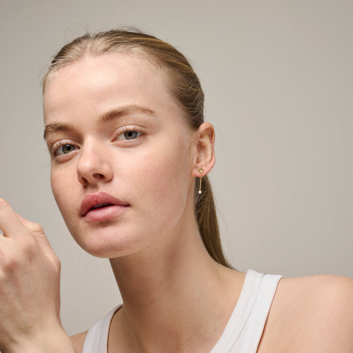 Enamel Sunshine Drop Earrings Daisy e423g-daisy visad på modell, diskreta guldörhängen med liten blomma och droppe. Modell e423g-daisy-2.