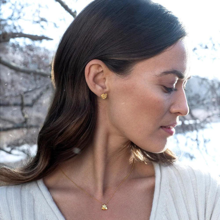 Flora Danica Granklöver halsband 18kt guld visat burna av kvinna i naturen med modell flc-ne-18k-g-2.