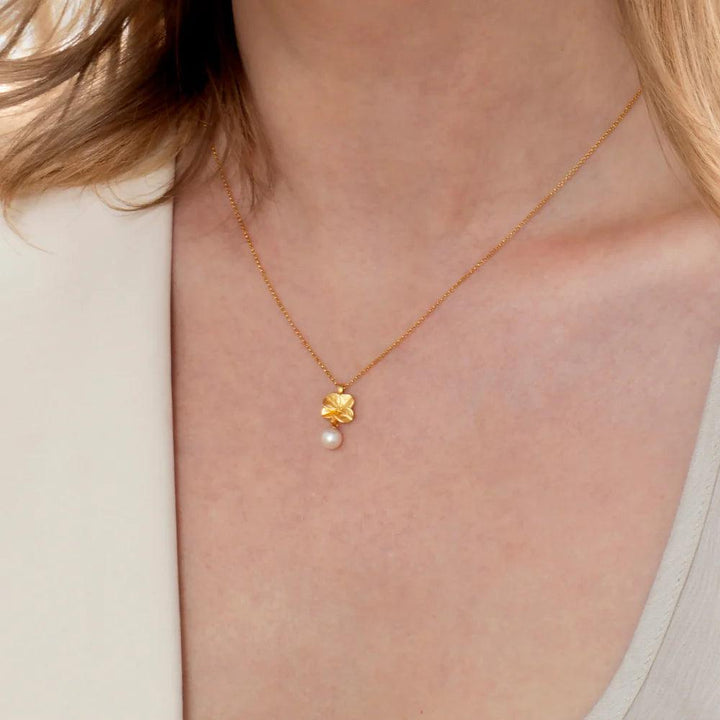 Flora Danica Fyrklöver Pärlhalsband i guldpläterat silver med klöverhänge och pärla på modell. Model907-flc-nepearl-g-2