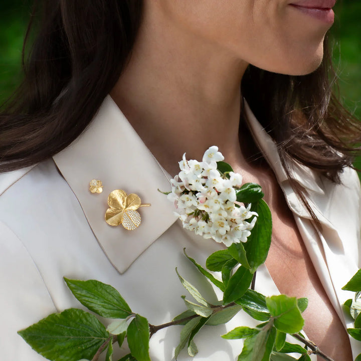 Flora Danica Fir Clover Pin Pavé Gilded ses bärs på en ljus skjorta, gyllene detalj med stenar. Modell 907-flc-pi-g-pave-2