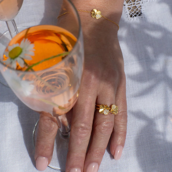 Flora Danica Fyrklöverring Pavé Gilded visar en elegant guldfärgad ring med fyrklöverdesign till hands. Modell 907-flc-ri-g-pave-001-2