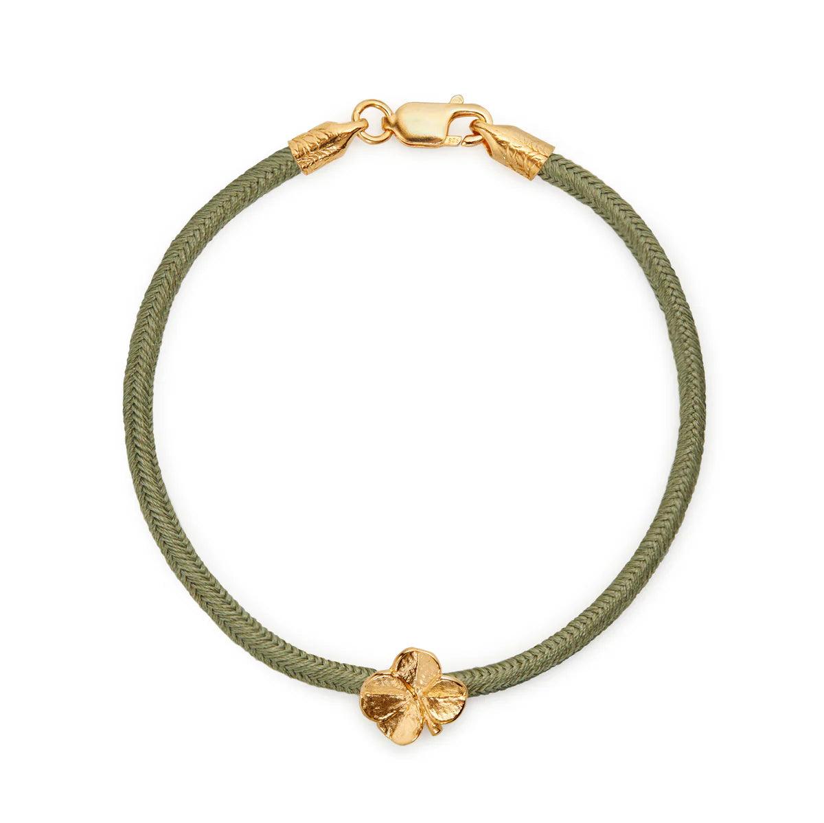 Flora Danica Fyrklöver sidenarmband Olive Gilt visar olivgrönt sidensnörearmband med klöverdetalj, modell 907-flc-silk-oliv-g-001-1.