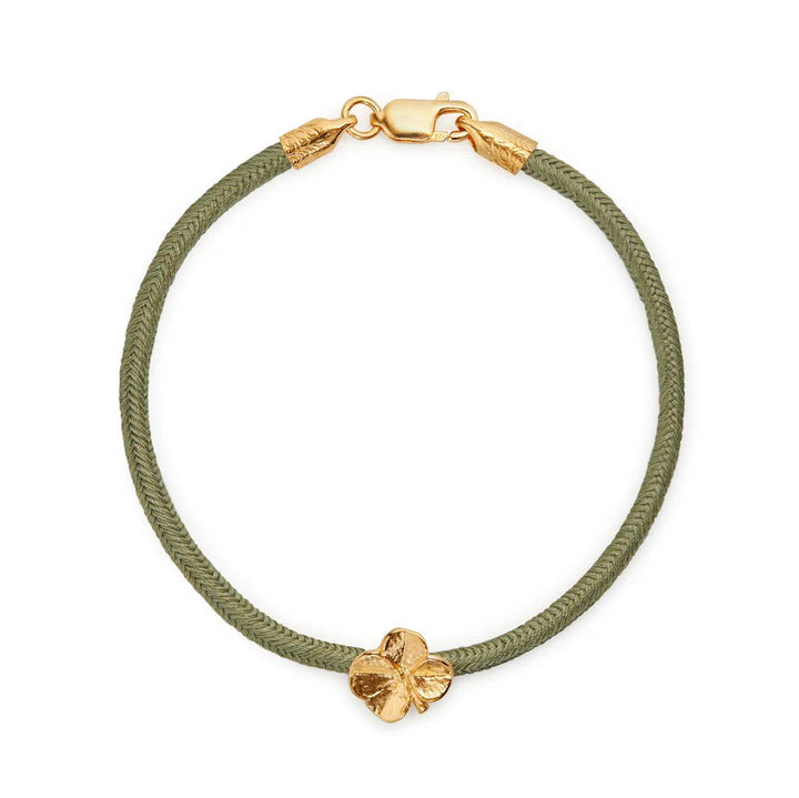 Flora Danica Fyrklöver sidenarmband Olive Gilt visar olivgrönt sidensnörearmband med klöverdetalj, modell 907-flc-silk-oliv-g-001-1.