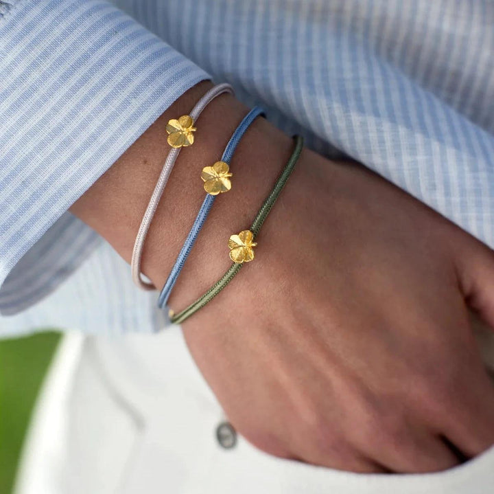 Flora Danica Fyrklöver Silk Armband Olive Gilt visar fyrklöver i guld på ett olivgrönt sidenband, modell 907-flc-silk-olive-g-001-2.