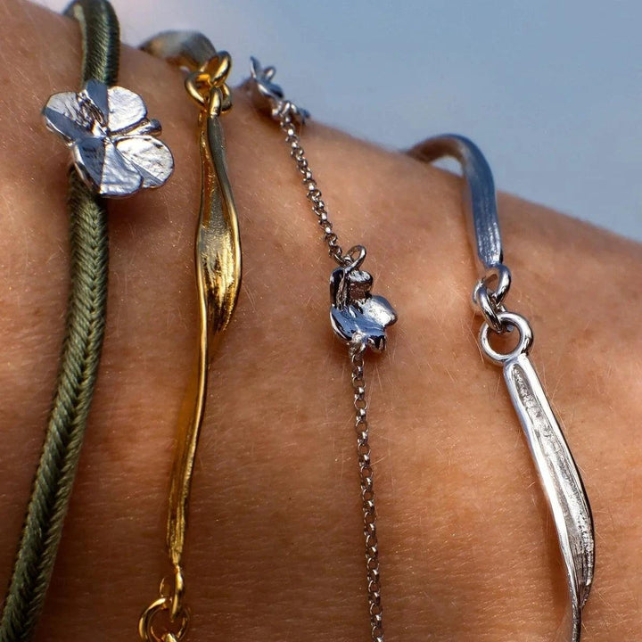 Flora Danica Clover Silk Armband Olive Silver syns på handleden, olivgrön sidensnöre och klöverdetalj. Modell907-FLC-SILK-OLIVE-S-001-2