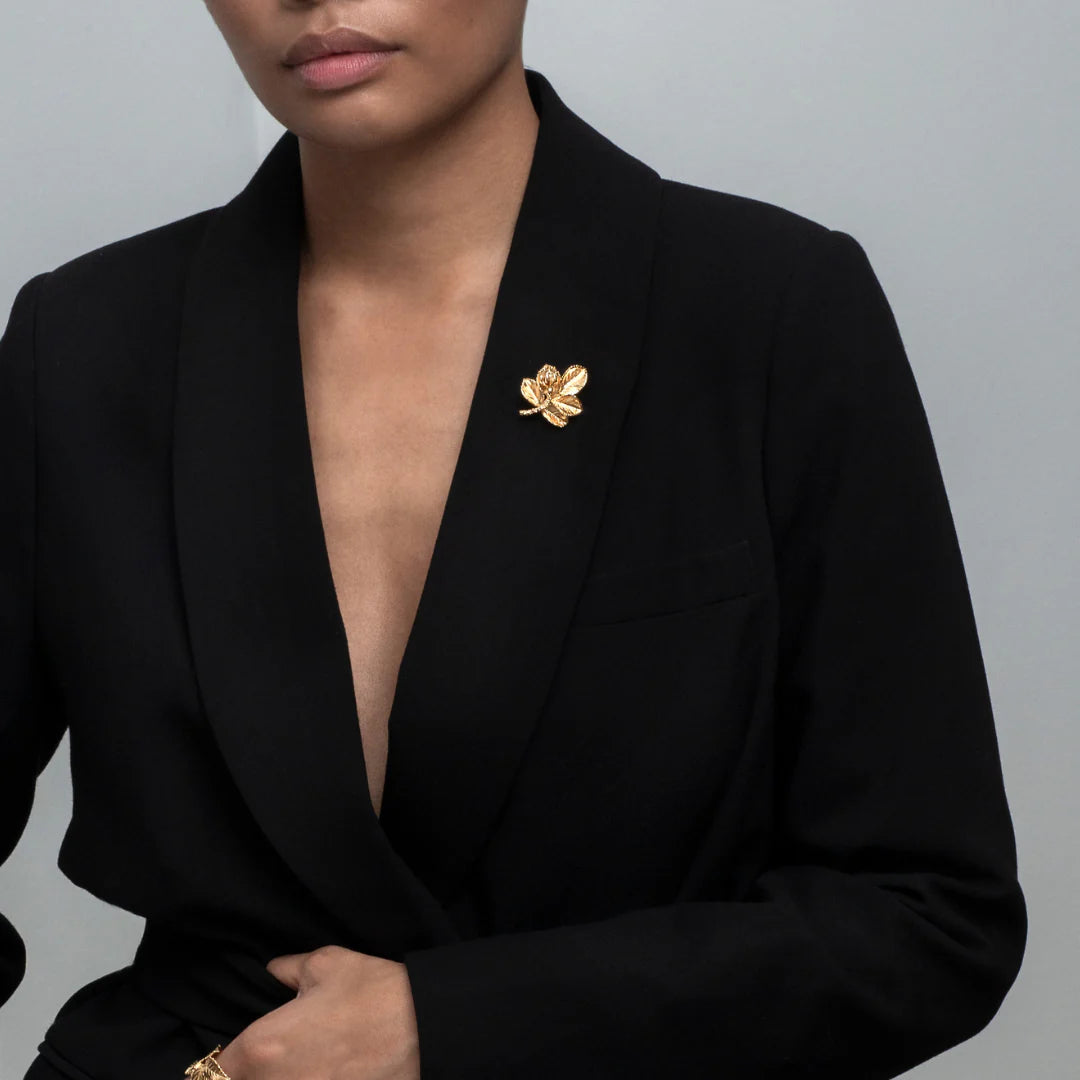 Flora Danica Rosenblad Brosch Förgylld rosbrosch visad på svart kavaj, elegant och detaljerad. Modell bro-g-1