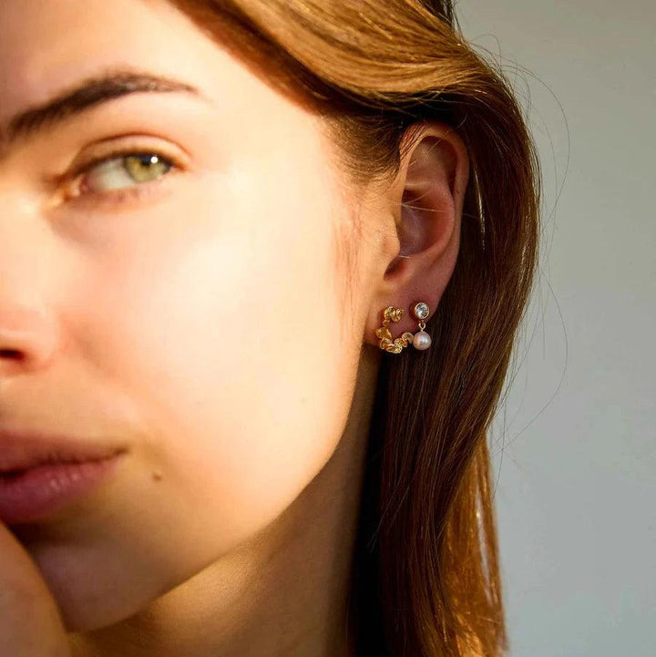 Hultquist Copenhagen Audrey Petite guldpläterade örhängen med pärla och sten på örat, modell S08603G-2.