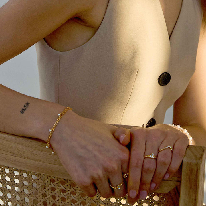 Hultquist Copenhagen Lainey guldpläterat armband bärs på handleden, pärldetaljer synliga. Modell S08591G-1