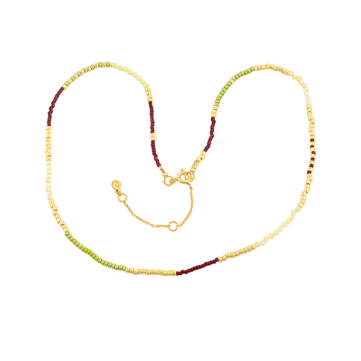 Hultquist Lucky halsband med pärlor i guld, grönt och vinrött på vit bakgrund. Modell S08637G-1.