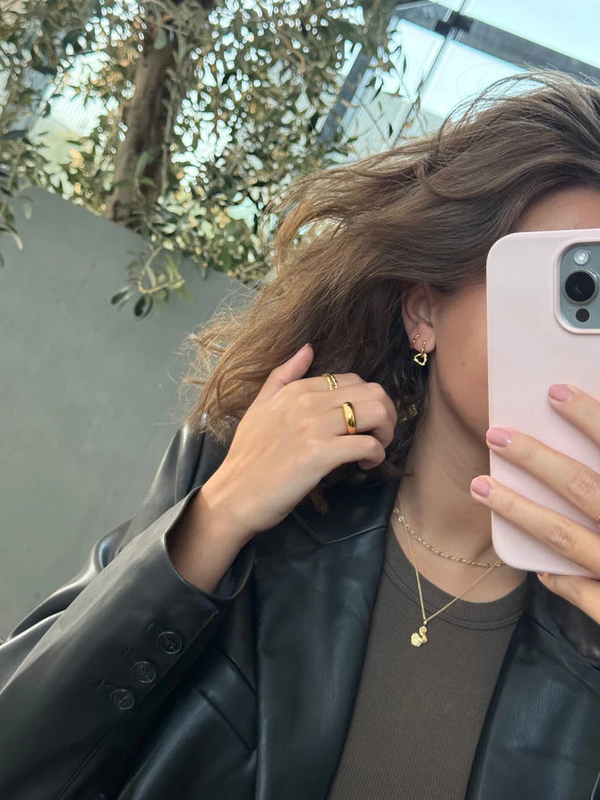 jeberg-smycken-piruett-dubbla-bågar i guldpläterat silver som bärs av kvinna med mörkt hår, modell 52840-2