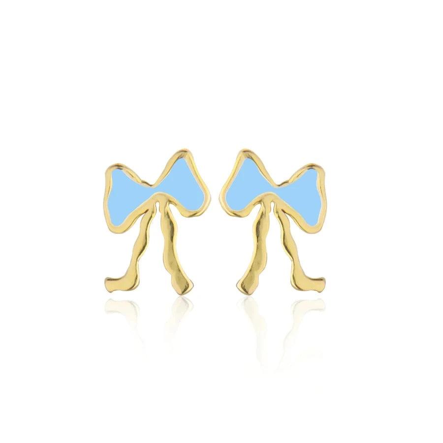 Jeberg Petite Bow Blue Stud Earrings visar en uppsättning små rosettörhängen i guld med ljusblå detalj. Modell 52810-1