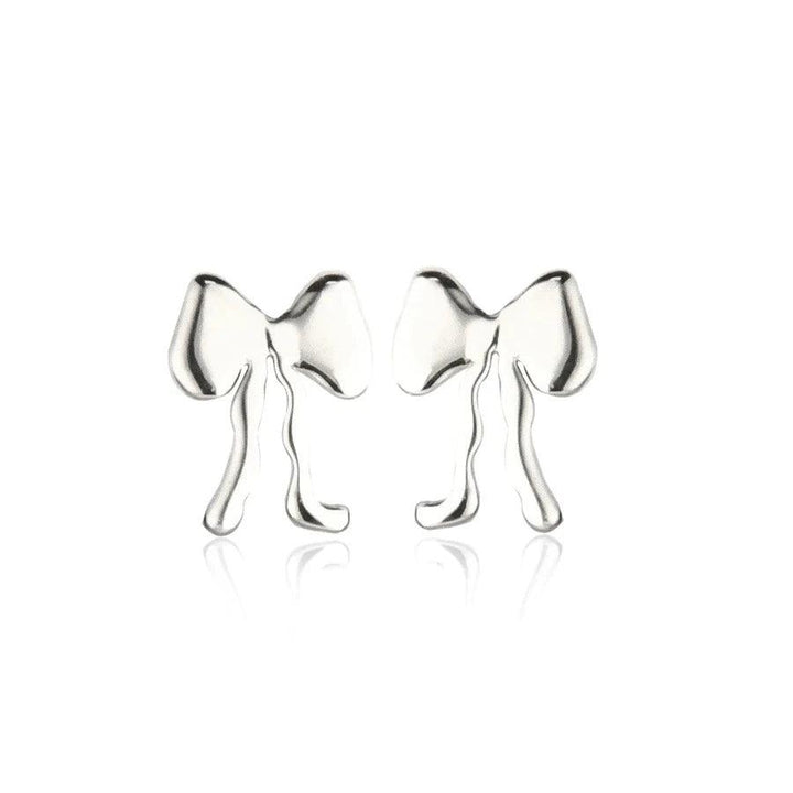 Jeberg Petite Bow Plain Stud i silver, eleganta rosettörhängen i blank finish på vit bakgrund. Modell 52822-1