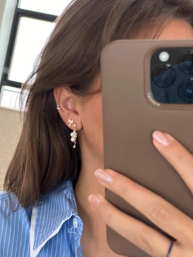 jeberg petite bow vita stud rosettörhängen bärs i örat, elegant design med pärldetaljer. Modell 52815-2