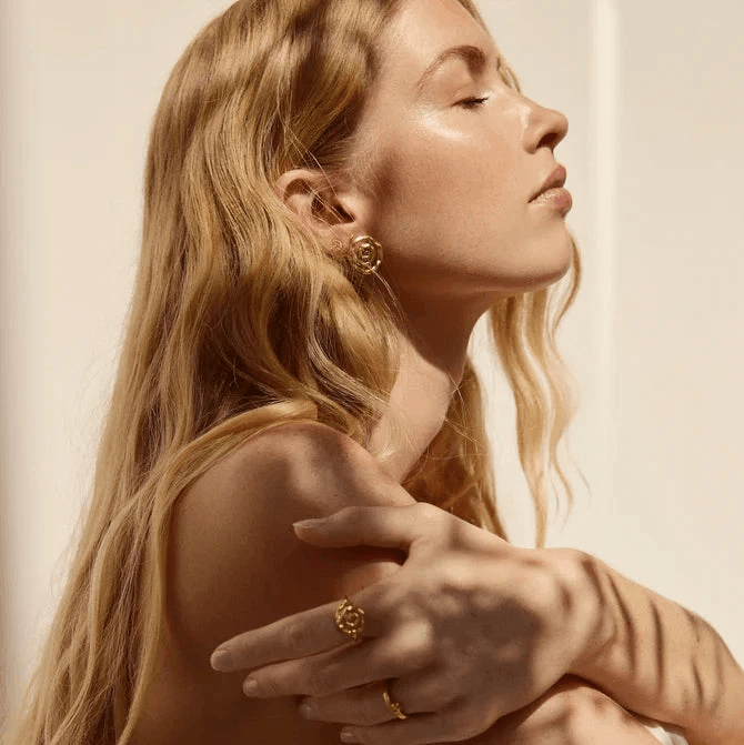 Jeberg Pirouette Darling örhängen visas på en kvinna, gyllene färg, elegant stil. Modell 52870-2