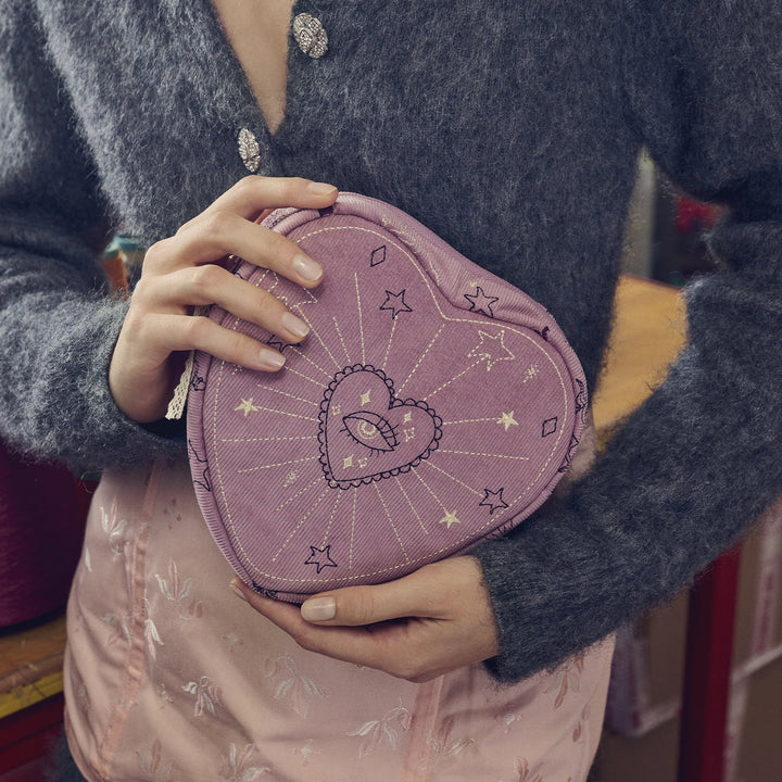 maanesten-hjärta-sminkväska-magisk-lila visad i hand med broderade öga och stjärnor, lila textil. Modell 4097-onezise