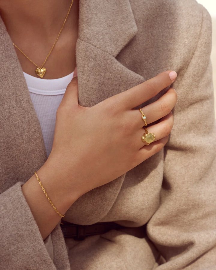 Moonstone Lisa guldpläterad ring visas på en hand med beige kappa, guldfärg, unik struktur. Modell 4745a-001-2.