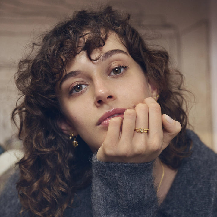 Maanesten Ria Gilded Ring visas på kvinnans hand, vågig design i guldlook, modell 4873a-001