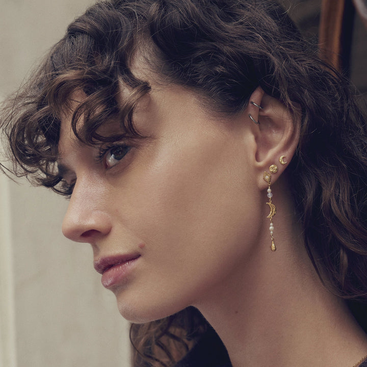 Maanesten Sissone guldpläterade örhängen som bärs på örat, elegant design med pärlor och halvmåne, modell 10033a