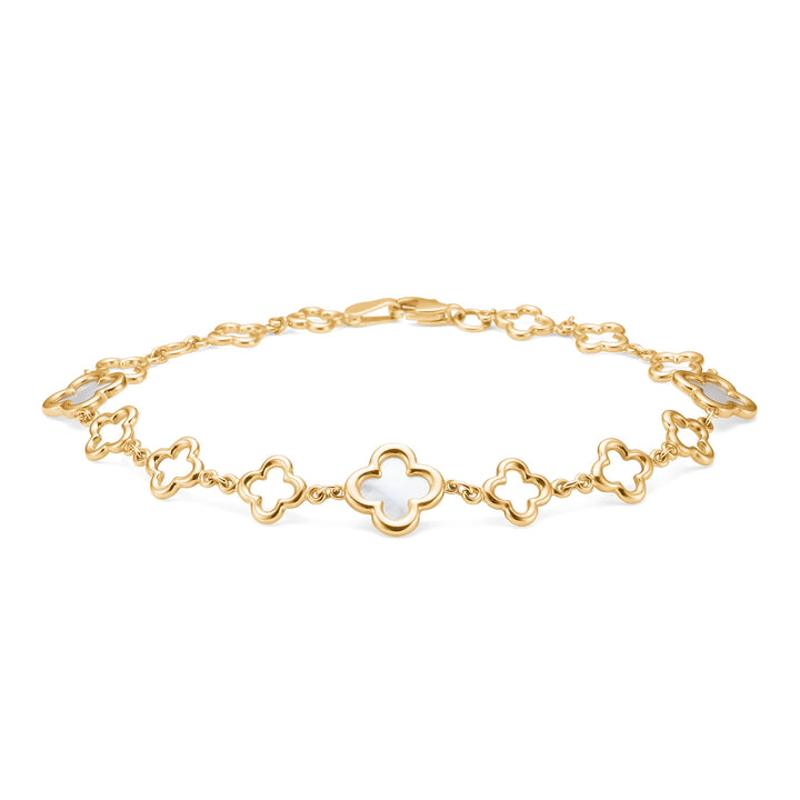 Mads Z Aurelia armband i 8kt guld med vita blomdetaljer, liggande på vit bakgrund. Modell 3356043-1
