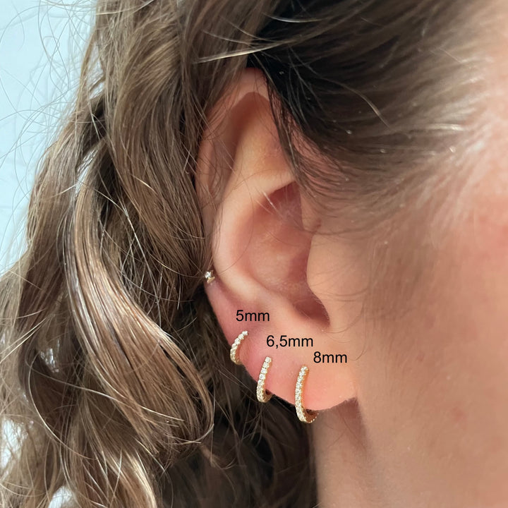 Maria Tash 6,5 mm Diamond Eternity Ring 18kt dyker upp i örat, elegant guldring med gnistrande diamanter. Modell XET65D-2