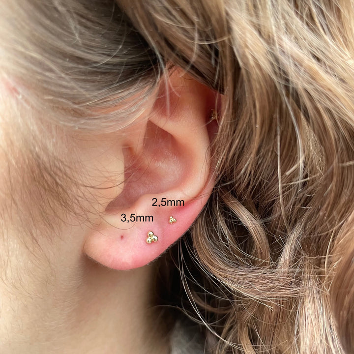 Maria Tash Large Three Ball Trinity Threaded Stud i guld bärs i örat, minimalistisk stil. Modell 35mm-x3btrl-001.