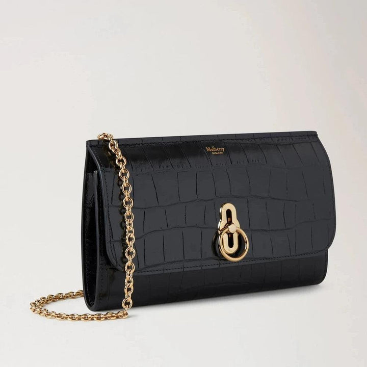 Mulberry Amberley Clutch Black Shiny Small Croc visar svart clutch i glänsande krokodilpräglat läder, guldkedja och lås. Modell RL8191641A100.