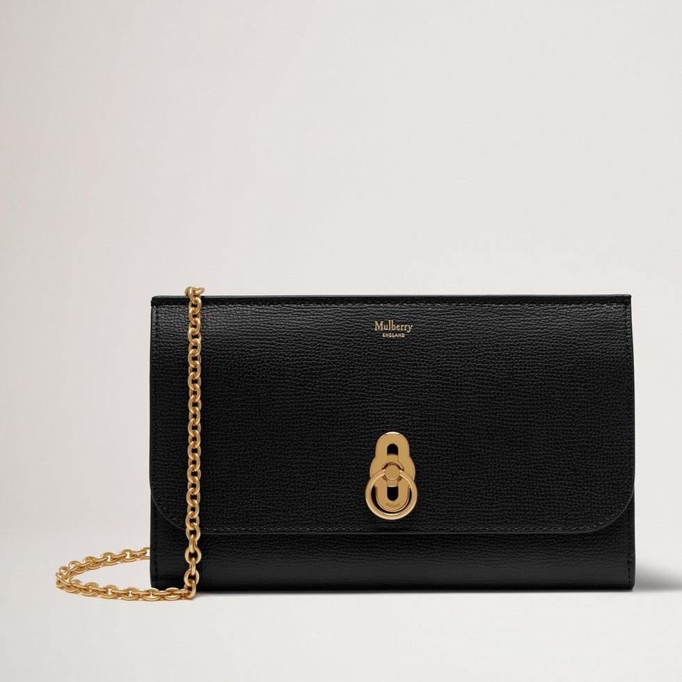 Mulberry Amberley Clutch Small Classic Grain Black ses som en elegant svart läderclutch med guldkedja och signaturlås. Modell RL6090205A100.
