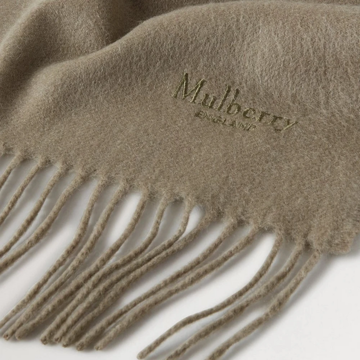 Mulberry Cashmere Scarf oliv, mjuk olivgrön cashmere scarf med fransar och broderad logotyp. Modell vs4460071q140