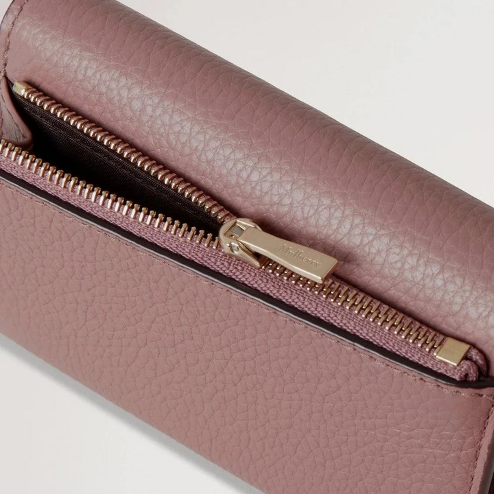 Mulberry Continental Trifold Wallet visar struktur och gulddragkedja i dammigt rosa läder, detaljerad utskärning.