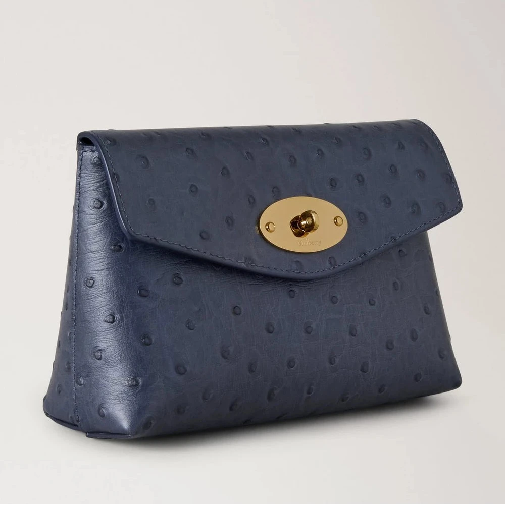 Mulberry Darley Cosmetic Pouch Ostrich Stormy Blue visar en blå kosmetikapåse i präglat läder med ett guldfärgat spänne. Modell RL8933738U918.