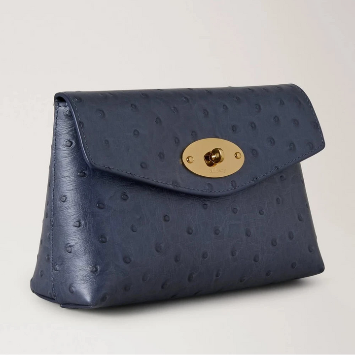 Mulberry Darley Cosmetic Pouch Ostrich Stormy Blue visar en blå kosmetikapåse i präglat läder med ett guldfärgat spänne. Modell RL8933738U918.