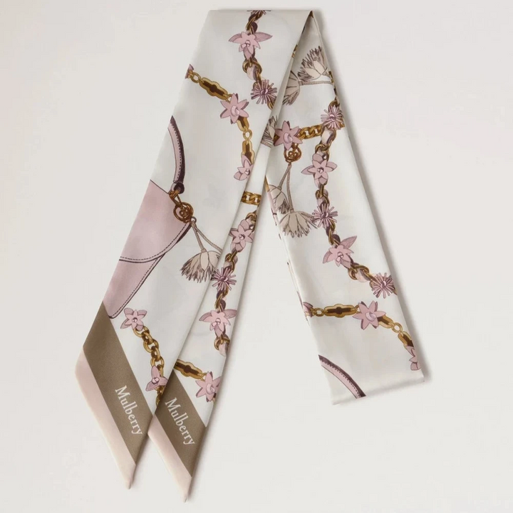 Mulberry Lana Bag and Chains Skinny Scarve Eggshell/Blossom Pink visar upp en smal sidenscarf med rosa och guldkedjedetaljer. Modell VS4849115W569