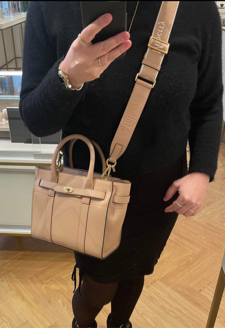 Mulberry-logo-webbing-strap-maple-rx0283000e631 bärs på axeln, beige väska med bred logorem, modell rx0283000e631.