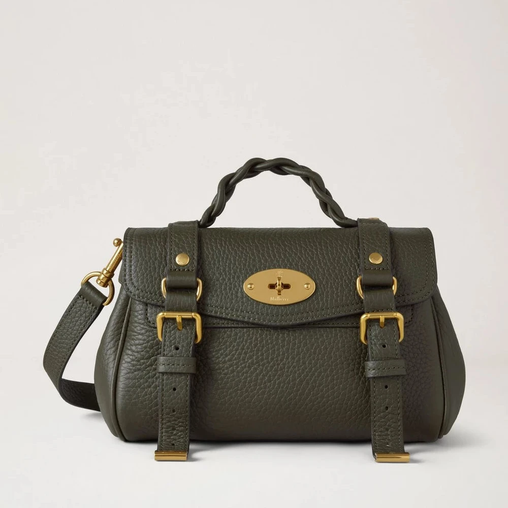 Mulberry Mini Alexa Juniper Green Heavy Grain visar en liten, grön läderväska med flätat handtag och guldmetalldetaljer. Modell RL6595736Q749.