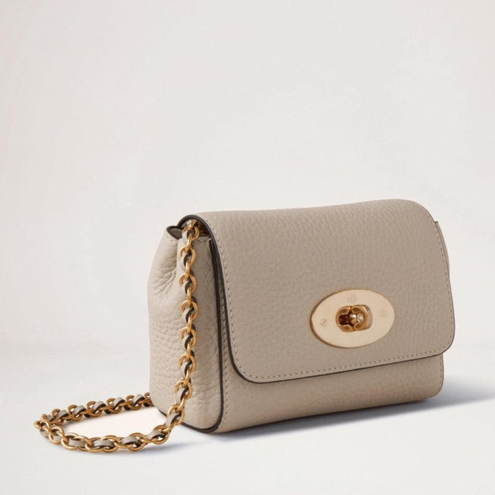Mulberry Mini Lily Heavy Grain Chalk visar en liten, beige axelväska i kraftigt läder med kedjeband och gyllene spänne. Modell RL7944736W160.