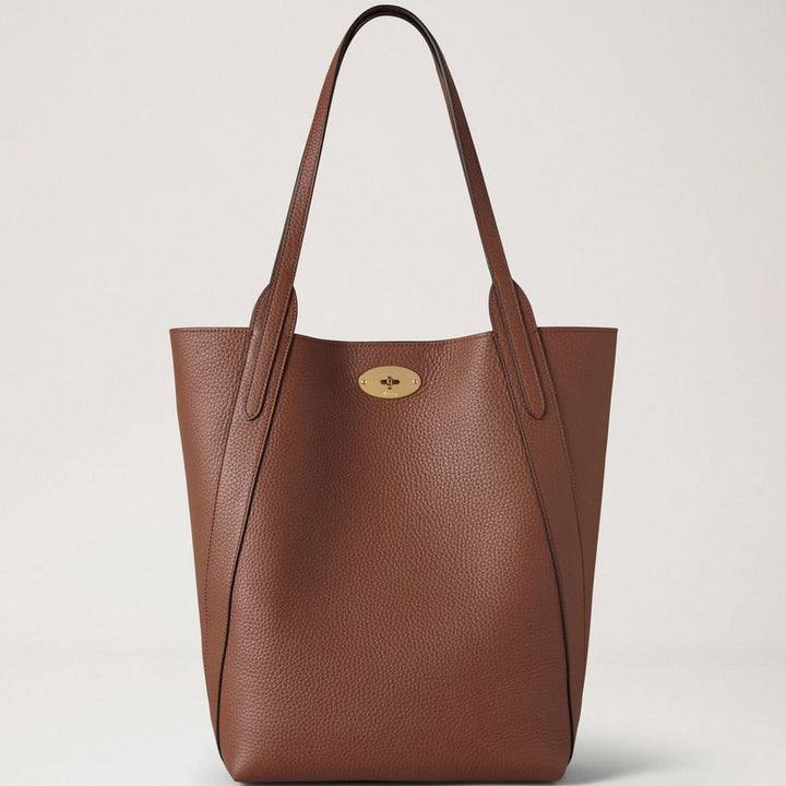 Mulberry North South Bayswater Heavy Grain Bright Oak visar upp en rymlig brun läderväska med två handtag och gulddetaljer. Modell hh9104736g222.