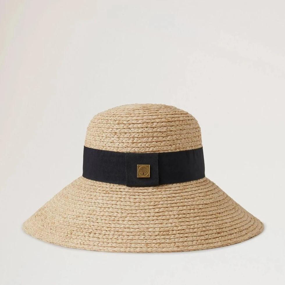 Mulberry Raffia Sun Hat Wide Brim shows a natural colored straw hat with a wide black band. Modell VH4136060H120-001-1
