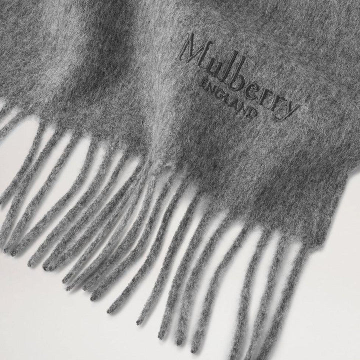 Mulberry Solid Merino Wool Scarf Grey Melange visar närbild av mjuk grå ull och fransar. Modell VS4240947C601