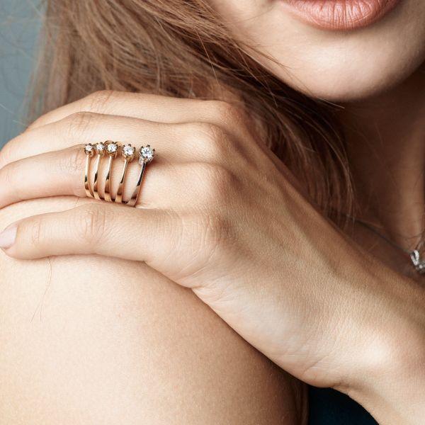 nuran-14kt-stjärna-diamantring-med-0-03ct-w-si-l1964-003rg-001 visas till hands, elegant guldring med briljant. Modell L1964-003RG-001