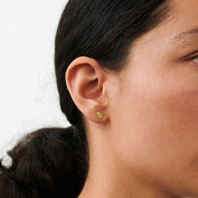 Pernille Corydon Elm Leaf öronproppar i förgylldhet syns på örat, diskret bladformad detalj. Modell E-329-GP