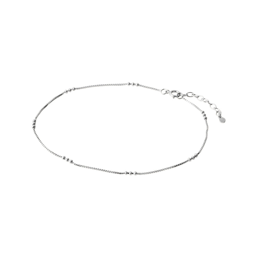 Pernille Corydon Eva Anklet Silver visar en enkel, slimmad fotlänk i silver med små kuldetaljer. Modell A-721-S-1