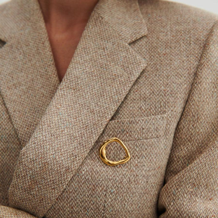 Pernille Corydon Gaia förgylld silverbrosch sett på en beige jacka, ekologisk gyllene form, modell C-001-GP