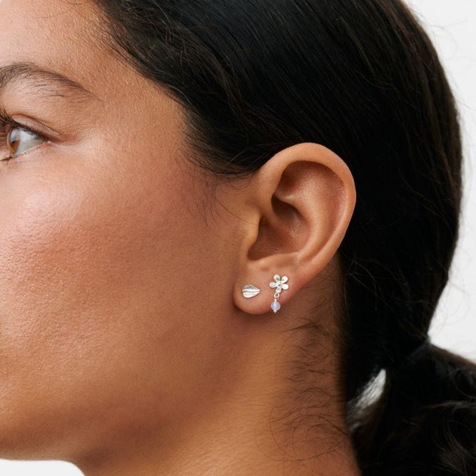 Pernille Corydon Meadow Örhängebox i silver visas i modellens öra, glansiga finish och blomdetalj. Modell C-121-S-1.