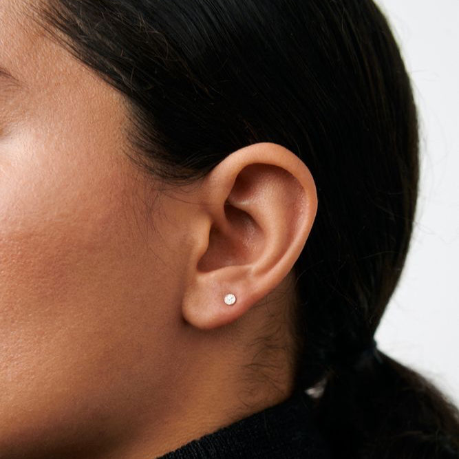 Pernille Corydon Micro Nature öronproppar i guldpläterat silver, visas på örat i närbild. Modell E-390-GP