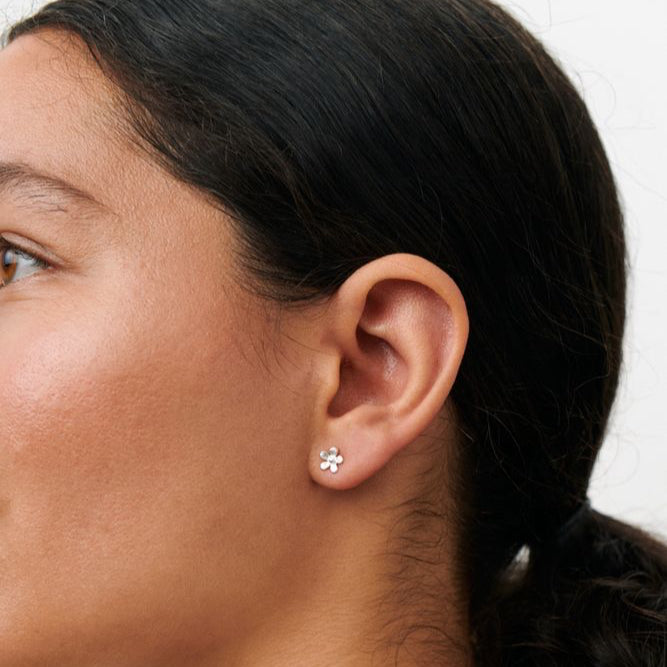 Pernille Corydon Mini Wild Poppy Stud Örhängen visar ett silverblommigt örhänge på modellen. Modell E-369-S