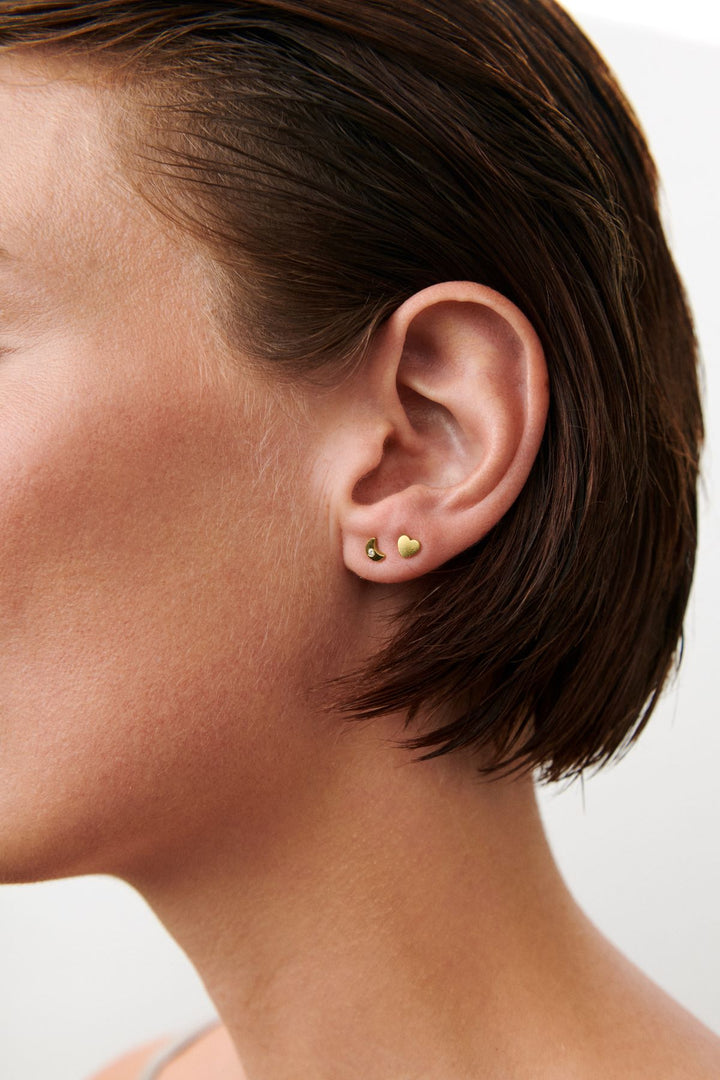 Pernille Corydon Night Light örhängen visas på örat, små guldpläterade örhängen i en minimalistisk design. Modell C-122-GP-2
